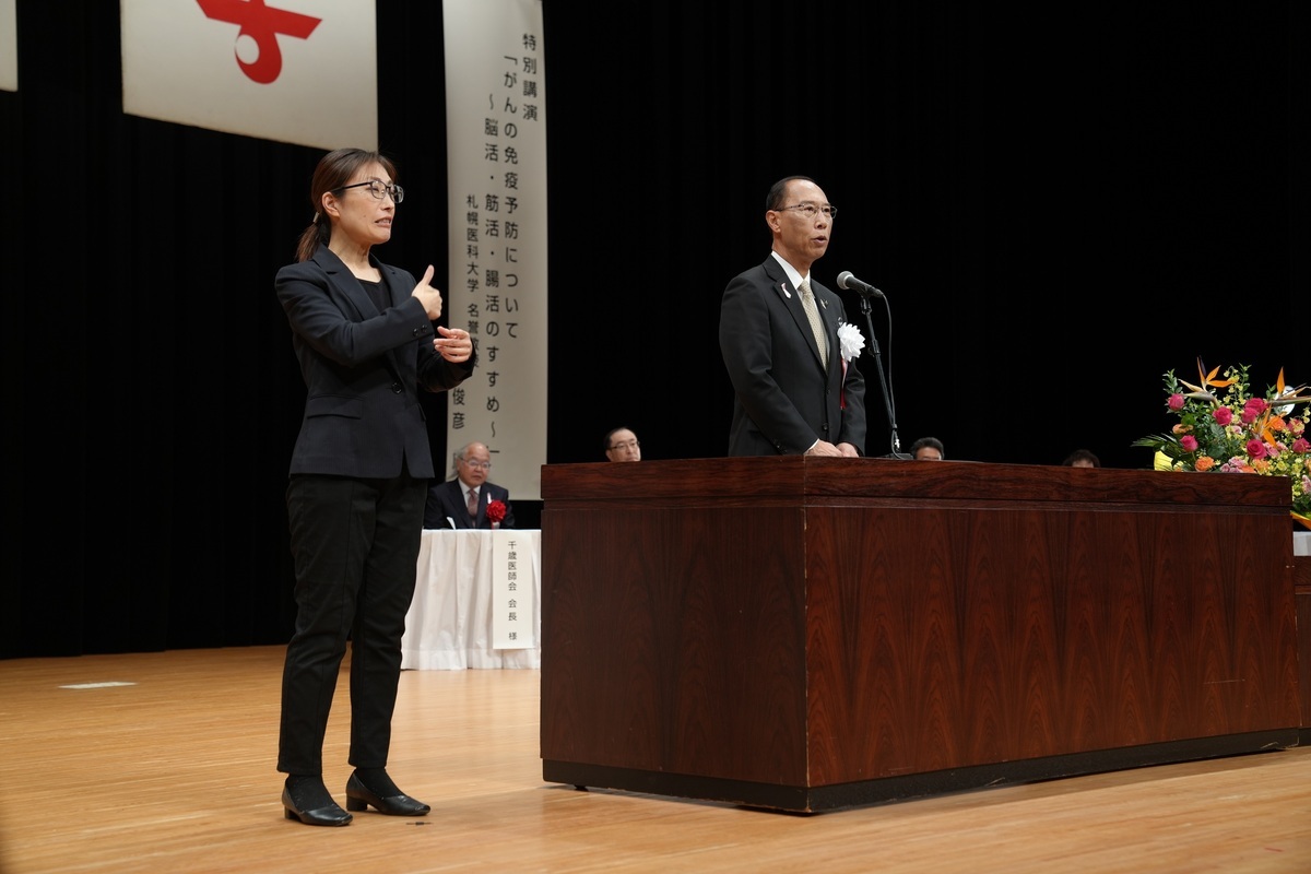 手話通訳者を横に挨拶をする市長の写真