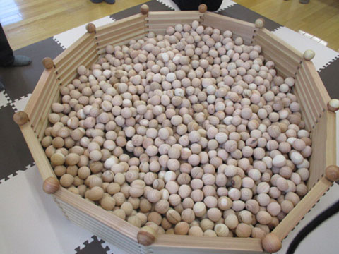 大量の木の玉を大きな入れ物に入れてプールのようにした木の玉プールの写真
