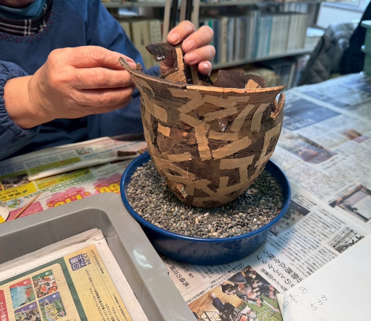 遺跡からバラバラで出土した土器を復元している様子。