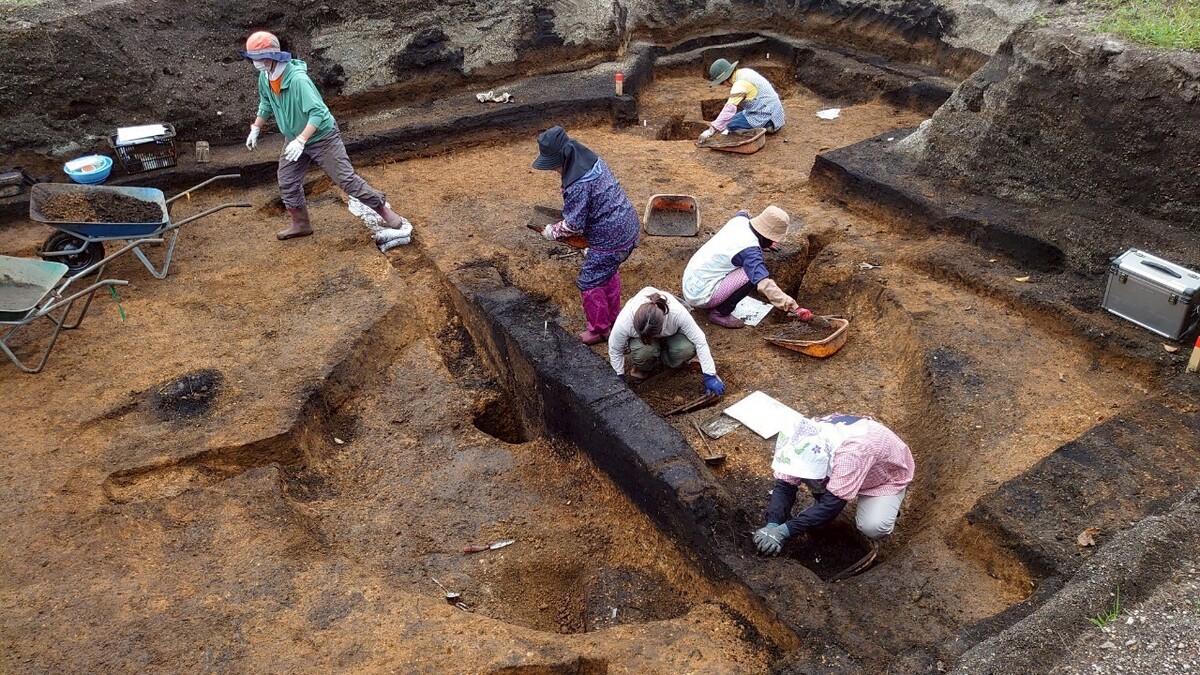 画面中央の竪穴住居を発掘している様子。
