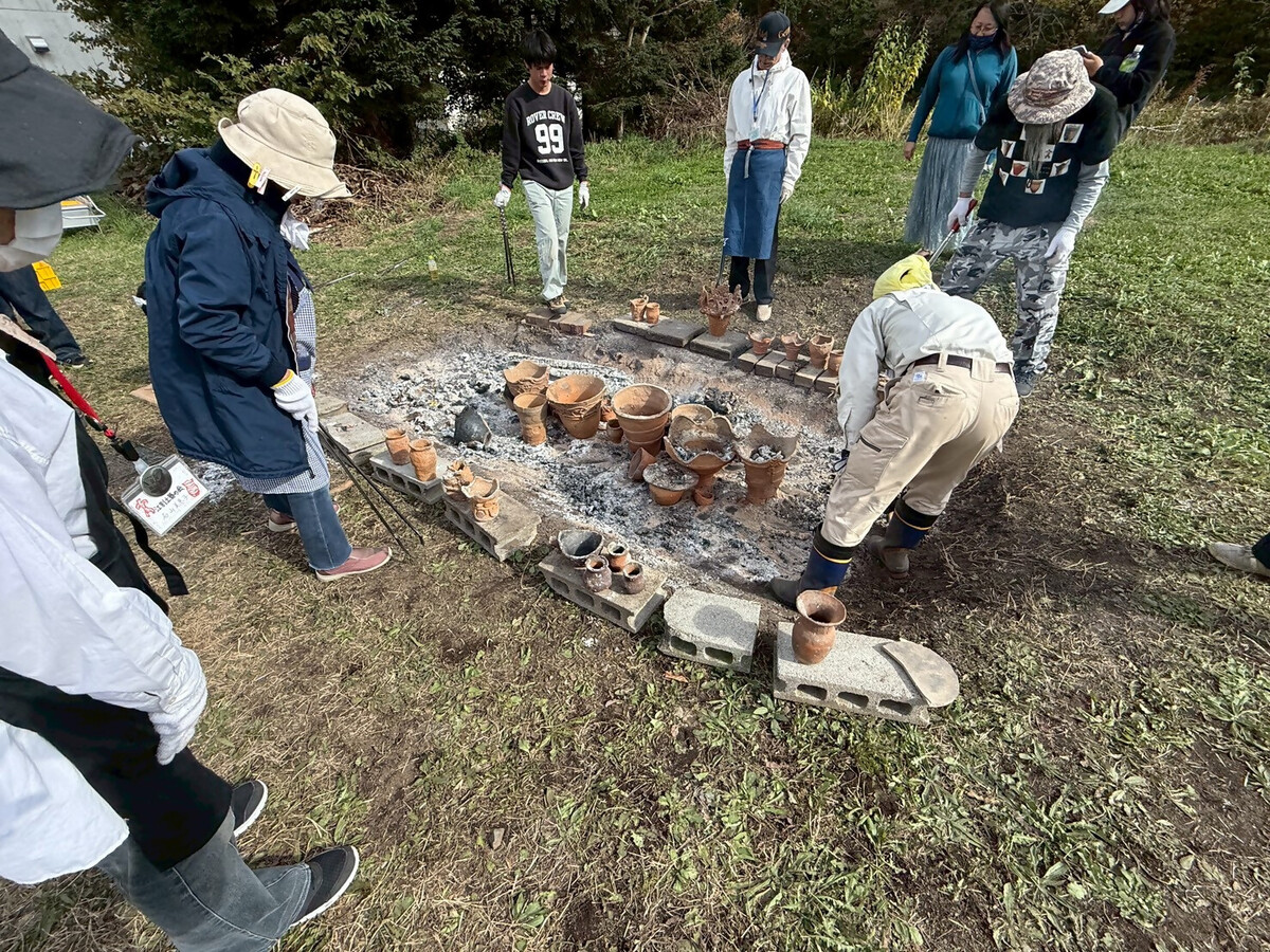 野焼き終了後の画像です。円形に製作した土器を並べて、冷ましている場面です。
