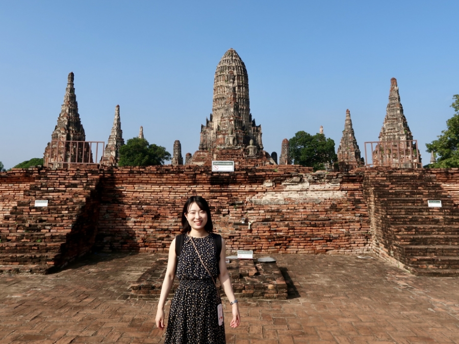 旅行先タイでの伊橋さんの写真。「ワット・チャイワッタナラーム」前で記念撮影。