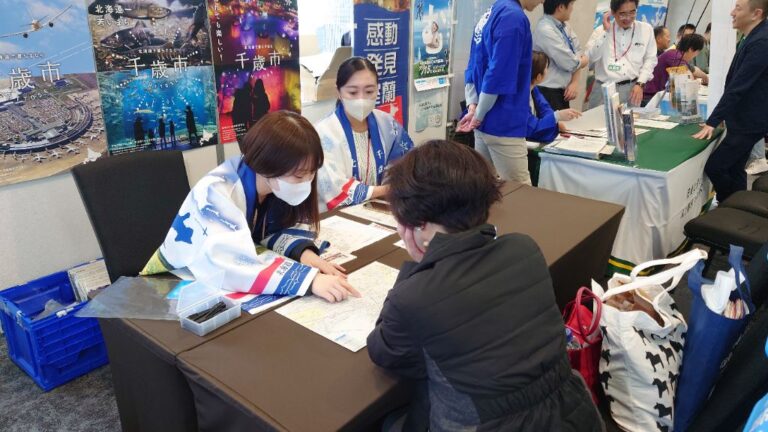 千歳市のブースで相談に対応する女性スタッフ2人の写真