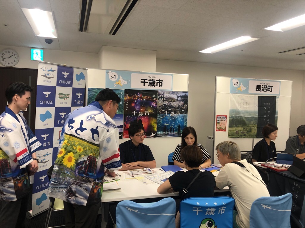 千歳市ブースで相談者の対応をする4人のスタッフの写真
