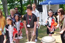支笏湖国際太鼓の子どもたちから太鼓の手ほどきを受ける参加者