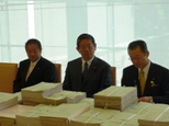 首相官邸に届けた22万筆を超える署名（左から今津衆議院議員、町村前官房長官、河村官房長官）