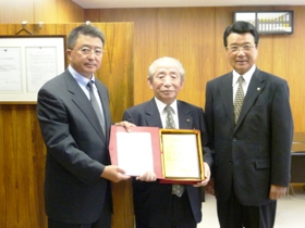 感謝状をいただいた藤本名誉会長（左から薄副主任、藤本名誉会長、山口市長）