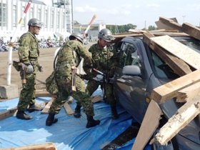 がれきの下敷きになった車両から被災者を救助する陸上自衛隊員